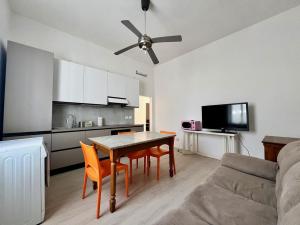 een woonkamer met een tafel en stoelen en een keuken bij Nuovissimo appartamento a Marina di Grosseto in Marina di Grosseto