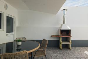 Zimmer mit einem Tisch, Stühlen und einer Leiter in der Unterkunft OCEAN VIEW House (airport&city) in Ponta Delgada
