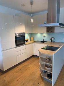 a kitchen with white cabinets and a stove top oven at Apartement stilvoll und großzügig in Windischgarsten