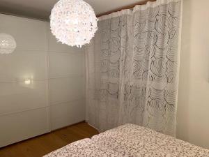 1 dormitorio con cama y lámpara de araña en Apartement stilvoll und großzügig en Windischgarsten