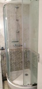 a shower with a glass door in a bathroom at Grand appartement proche de Paris in Brunoy