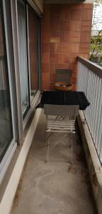 stół i krzesło na balkonie w obiekcie Grand appartement proche de Paris w mieście Brunoy