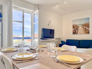 a dining room with a table with chairs and a tv at Spacieux appartement quartier de La Chaume - 4 pers in Les Sables-dʼOlonne