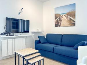 a living room with a blue couch and a tv at Spacieux appartement quartier de La Chaume - 4 pers in Les Sables-dʼOlonne
