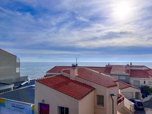 a building with red roofs next to the ocean at Spacieux appartement quartier de La Chaume - 4 pers in Les Sables-dʼOlonne +2 photos