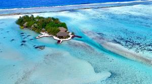 uma ilha no oceano com um resort em EDEN Private Island TAHAA em Patio
