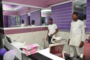 two men standing in front of a mirror in a salon at SPA LAVENDER AND SUITES in Port Harcourt