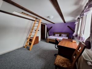 a room with a ladder and a bed and a desk at Chalupa U Křížku Říčky v Orlických horách in Říčky