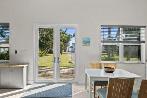 a kitchen with a white door and a table and chairs at 2/1 Riverside Retreat with Loft in Fort Pierce