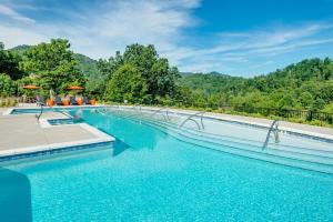 une piscine avec de l'eau bleue et des arbres dans l'établissement Cornerstone Cabin at Springdale, à Canton
