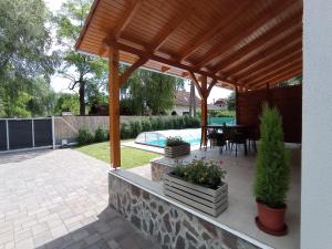 um pátio com uma pérgola de madeira e uma mesa em Relax Apartment em Fonyód