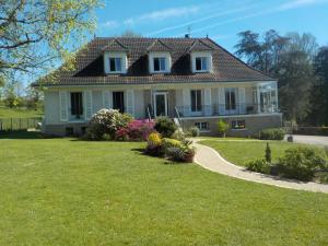 una gran casa blanca con un patio de césped en CHARMANT APPARTEMENT DANS MAISON DE CARACTERE en Saint-Brice-sur-Vienne