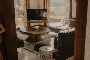 a living room with a table and a tv at Misty Mountain Manor in Uki