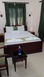 a bedroom with a bed with a bottle of water on a table at Elim Homestay Fort Kochi in Cochin