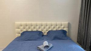 - un lit avec une couette bleue et 2 oreillers dans l'établissement ЖК Альфа Бета, à Kostanay