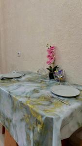 une table avec deux plaques et une fleur sur elle dans l'établissement ЖК Альфа Бета, à Kostanay