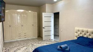 - une chambre avec un lit bleu et un placard dans l'établissement ЖК Альфа Бета, à Kostanay