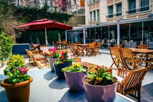 a patio with tables and chairs and potted plants at Notte Hotel in Ankara