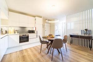 a kitchen and dining room with a table and chairs at On The Square Flat - City Center by House and People in Braga +12 photos