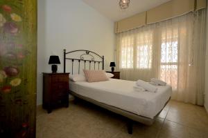 a bedroom with a large bed and a window at Águilas Delicias Piscina Wifi AC Parking Gratis in Águilas