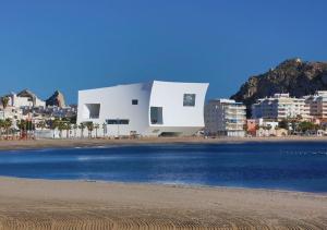 a white building on the beach next to the water at Águilas Delicias Piscina Wifi AC Parking Gratis in Águilas