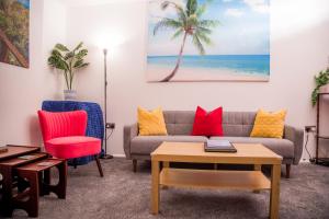 a living room with a couch and a palm tree at Lucky Home - Ideal for Trade, Consultants & Family - Near Alton Towers, 3 Bedrooms - 4 Beds - 5 People in Stoke on Trent