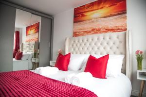 a bedroom with a large bed with red pillows at Lucky Home - Ideal for Trade, Consultants & Family - Near Alton Towers, 3 Bedrooms - 4 Beds - Max 5 Guests in Stoke on Trent