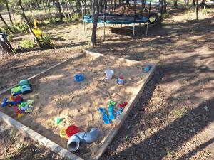 a sandbox with toys in the sand with a swing at Casa Natura Montseny in El Brull