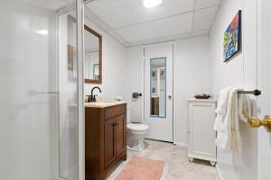 a white bathroom with a sink and a toilet at Highland Hideaway in Lilydale