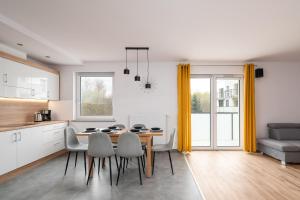 a kitchen and dining room with a table and chairs at Apartament GOJA Podzamcze in Wałbrzych