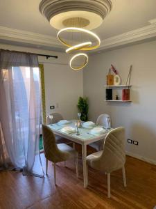 a dining room table with chairs and a chandelier at Nile View Cozy Appartment in Cairo +8 photos