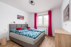 a bedroom with a bed and a window with pink curtains at Apartament GOJA Podzamcze in Wałbrzych