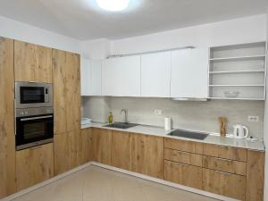 een keuken met witte apparaten en houten kasten bij Family Seaview Ap. Korabi 304 in Durrës