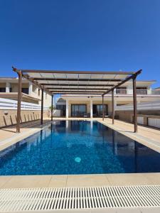 a large swimming pool with a canopy in a building at Fabulous beach front house with pool in Larnaca