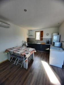 ein Wohnzimmer mit einem Tisch und einer Küche in der Unterkunft Chez Marc in Lubersac