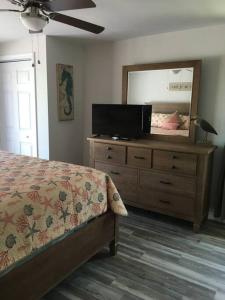 a bedroom with a bed and a dresser with a mirror at Surfside Beach/ Capt. Jacks ~50 FT From Beach 3br/3ba in Myrtle Beach