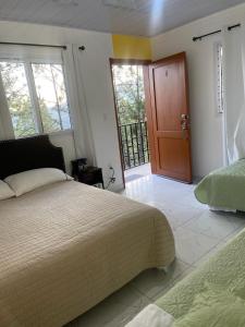 1 dormitorio con 1 cama y puerta de madera en Mirador Hotel Aoki, en Valle de Ángeles