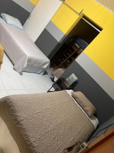 1 dormitorio con cama y pared amarilla y gris en Mirador Hotel Aoki, en Valle de Ángeles