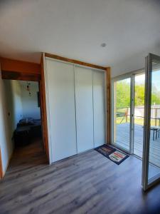 een lege kamer met een glazen schuifdeur en een balkon bij Chez Marc in Lubersac