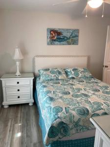 ein Schlafzimmer mit einem Bett und einem Nachttisch mit einer Lampe in der Unterkunft Surfside Beach/ Capt. Jacks ~50 FT From Beach 3br/3ba in Myrtle Beach