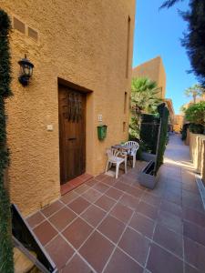 Un patio con una puerta de madera y una mesa y sillas. en Beach Bungalow Port,free parking, en Estepona