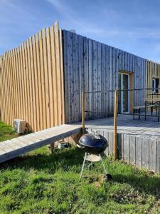 een barbecue die op het gras voor een gebouw staat bij Chez Marc in Lubersac