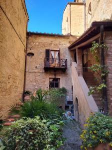 Edificio antiguo con balcón y escalera en La Torre Nomipesciolini en San Gimignano