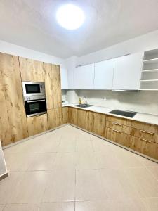 een lege keuken met witte kasten en witte apparaten bij Family Seaview Ap. Korabi 304 in Durrës