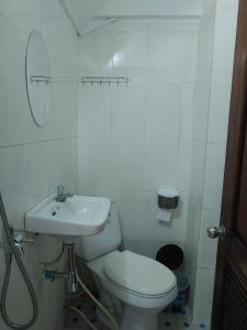 een witte badkamer met een toilet en een wastafel bij CENTRO GUEST HOUSE in Siem Reap