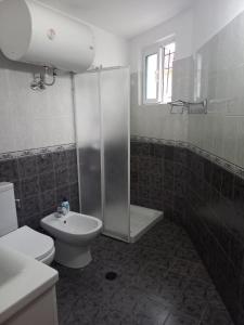 a bathroom with a shower and a toilet and a sink at VodaHouse in Gjirokastër