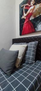 łóżko z poduszkami i obraz kobiety w obiekcie Alsancak seaside 50 m Single room green w mieście Konak