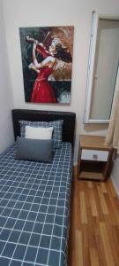 a bedroom with a bed with a painting on the wall at Alsancak seaside 50 m Single room green in Konak