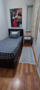 a bedroom with a bed and a painting on the wall at Alsancak seaside 50 m Single room green in Konak