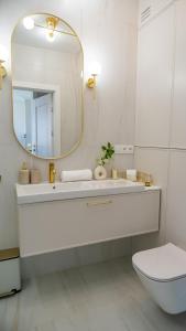 La salle de bains blanche est pourvue d'un lavabo et d'un miroir. dans l'établissement Lake Rental Pratum 43, à Mikołajki